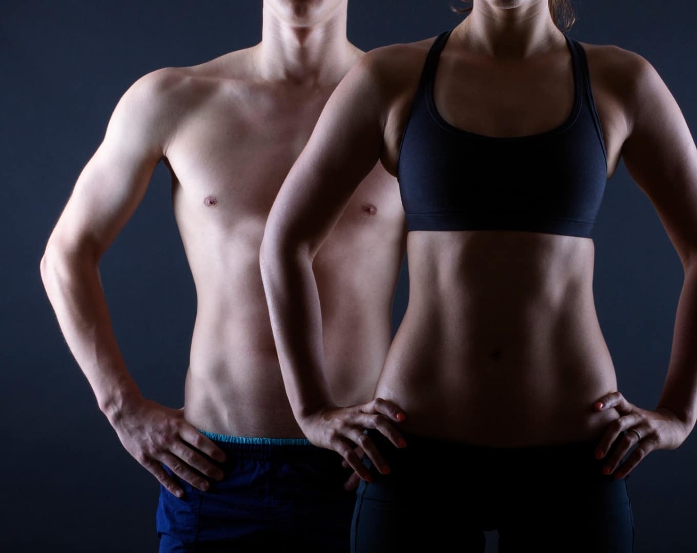 man and woman on a dark background with toned bodies