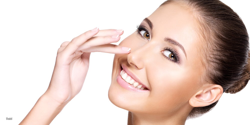 Female touching her nose with one hand